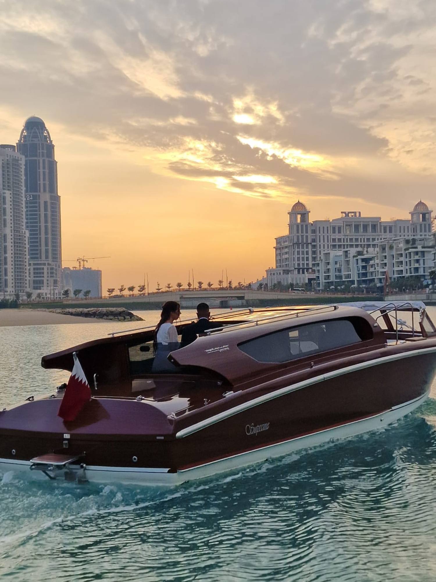 Grupo de amigos dando un Paseo en Barco al atardecer por la Bahía de la Perla en Doha